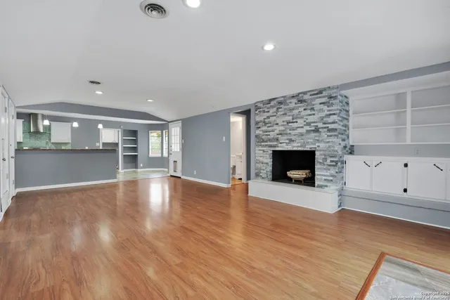 an empty room with wooden floor and fireplace