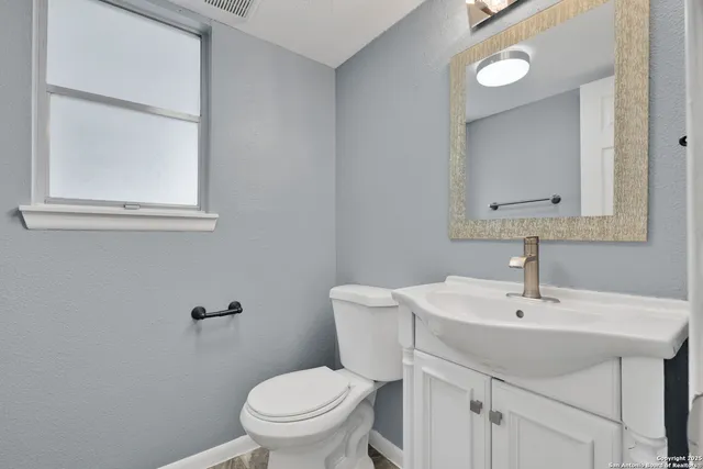 a bathroom with a toilet sink and mirror