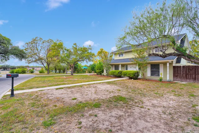 a view of a house with a yard and potted plants