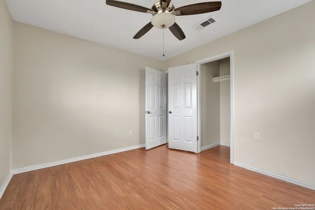 a view of empty room with wooden floor