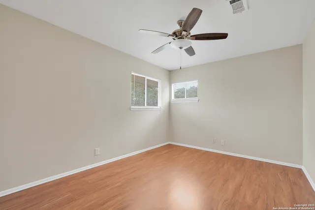 a view of a big room with wooden floor and windows