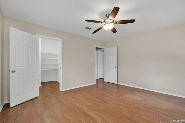 a view of an empty room with wooden floor
