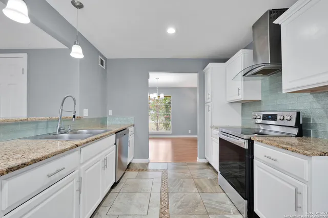a kitchen with stainless steel appliances granite countertop a sink and stove