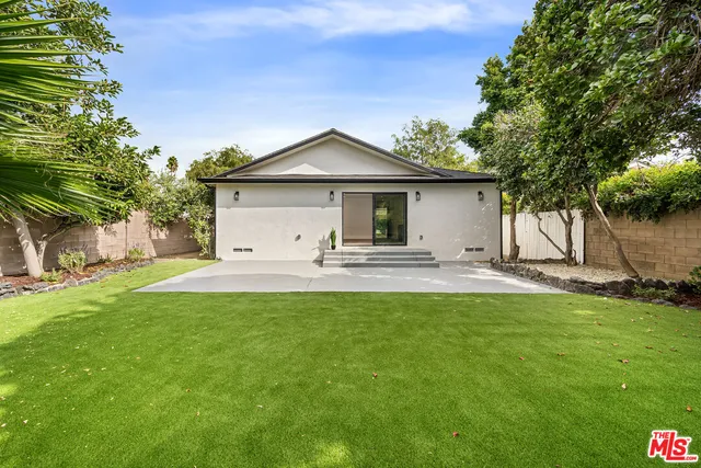 a view of a house with backyard and a tree