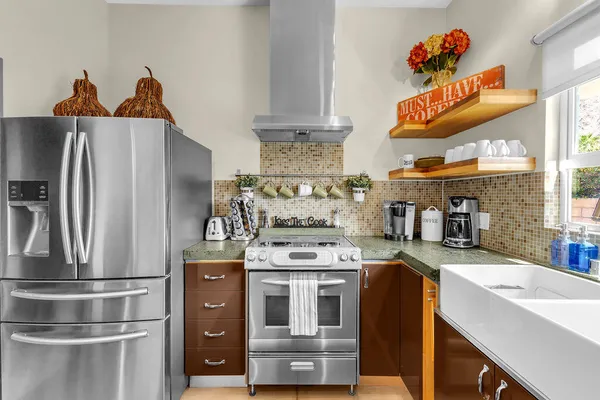 a kitchen with refrigerator a stove and oven