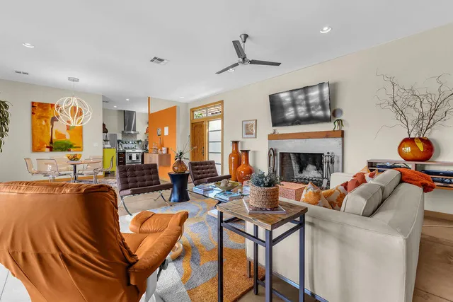 a living room with furniture a flat screen tv and a window