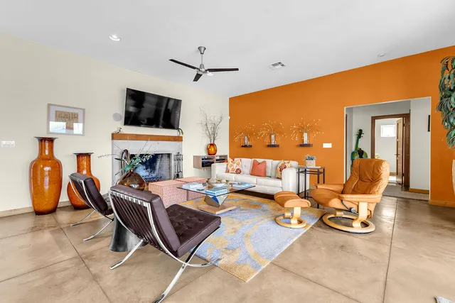 a living room with fireplace furniture and a large window