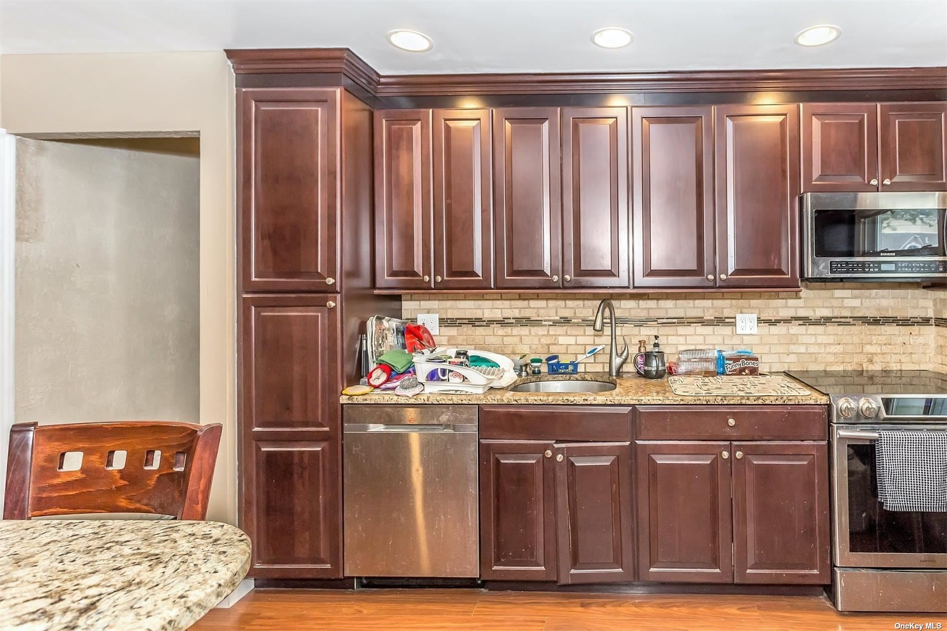 a kitchen with stainless steel appliances granite countertop a refrigerator stove and cabinets