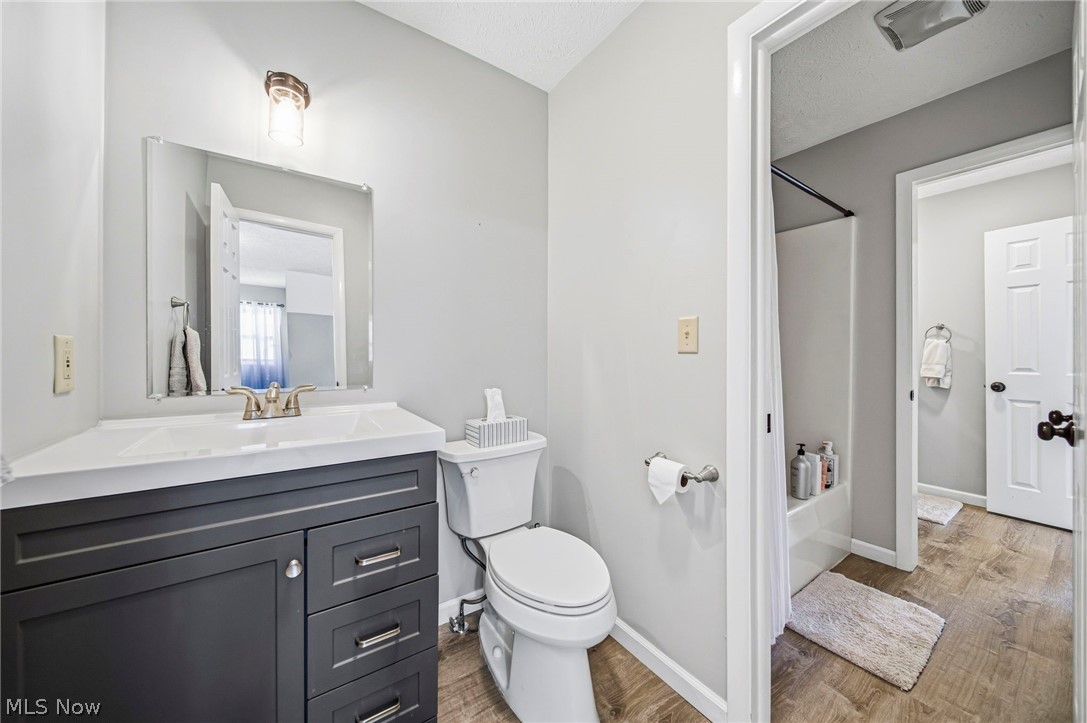 2850 South Ridge Road Perry, OH 44081 - Photo 20 of 41 Bathroom with vanity, wood finished floors, and shower / bathtub combination with curtain