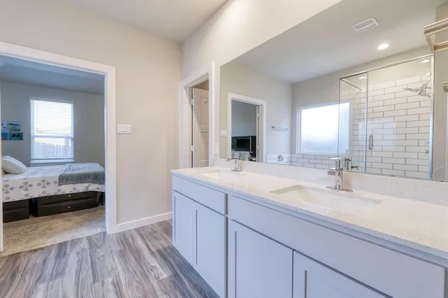 a en suite bathroom with a double vanity sink and a mirror