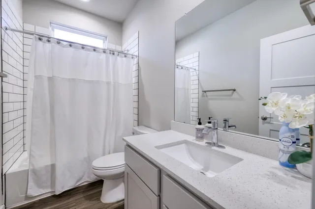 a bathroom with a granite countertop sink toilet and shower