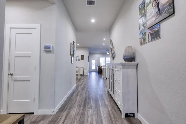 a view of a hallway with wooden floor and staircase