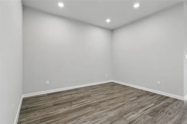 a view of room with wooden floor and white walls