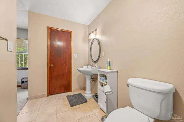 a bathroom with a toilet a sink and a mirror