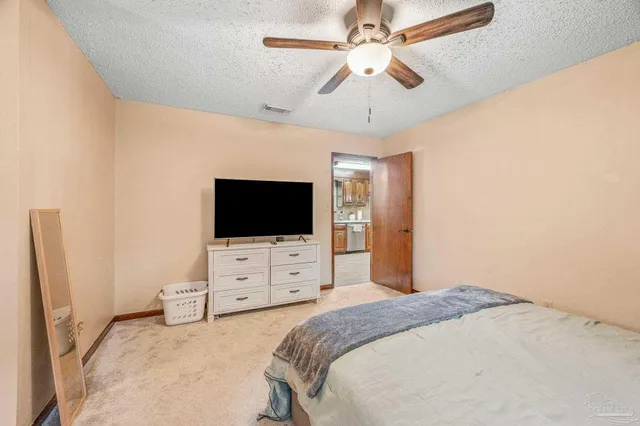 a bedroom with a bed and a flat tv screen on dresser