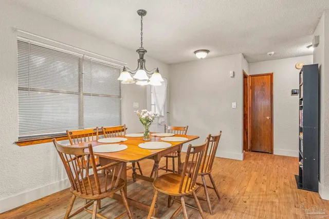 a view of a dining room with furniture a chandelier and wooden floor