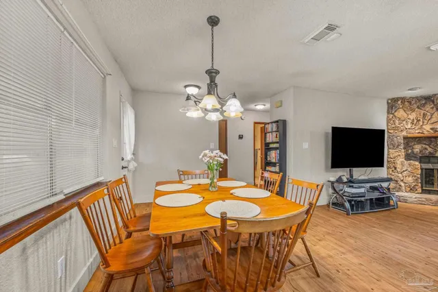 a dining room with furniture a chandelier and wooden floor
