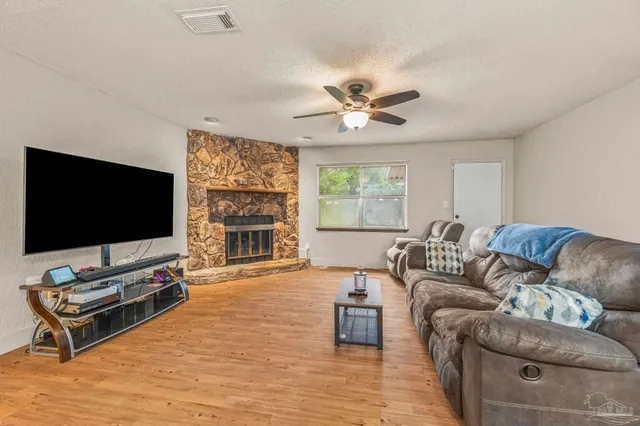 a living room with furniture flat screen tv and a large window