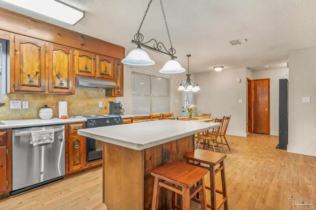 a kitchen with stainless steel appliances granite countertop a sink a stove and a refrigerator