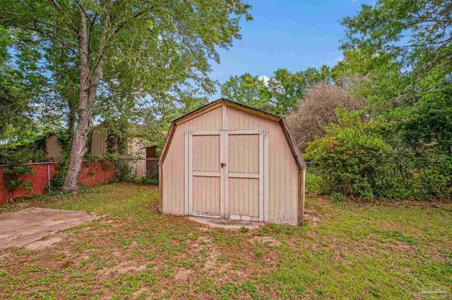 a view of a house with a yard and large tree