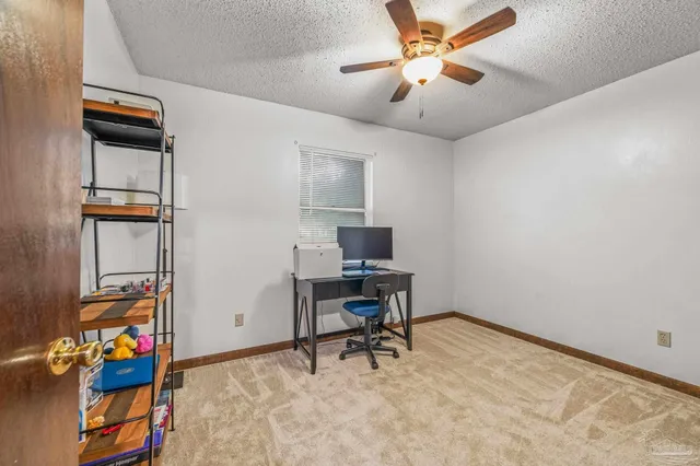 a view of a workspace with furniture and a window