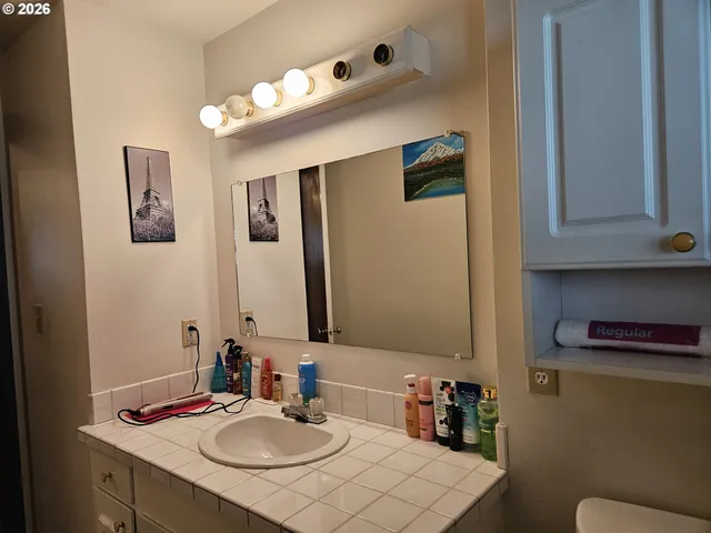 a bathroom with a sink vanity and mirror