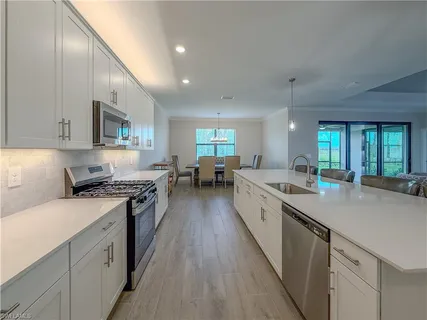 a large kitchen with stainless steel appliances granite countertop a lot of counter space and wooden floors