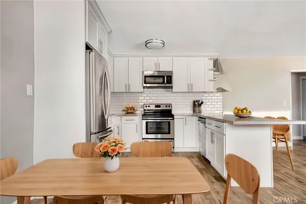 a kitchen with stainless steel appliances granite countertop a stove refrigerator and microwave