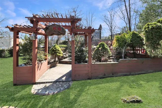 a view of a yard with plants and a fountain
