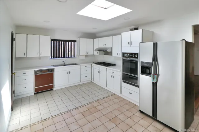 a kitchen with white cabinets and white appliances