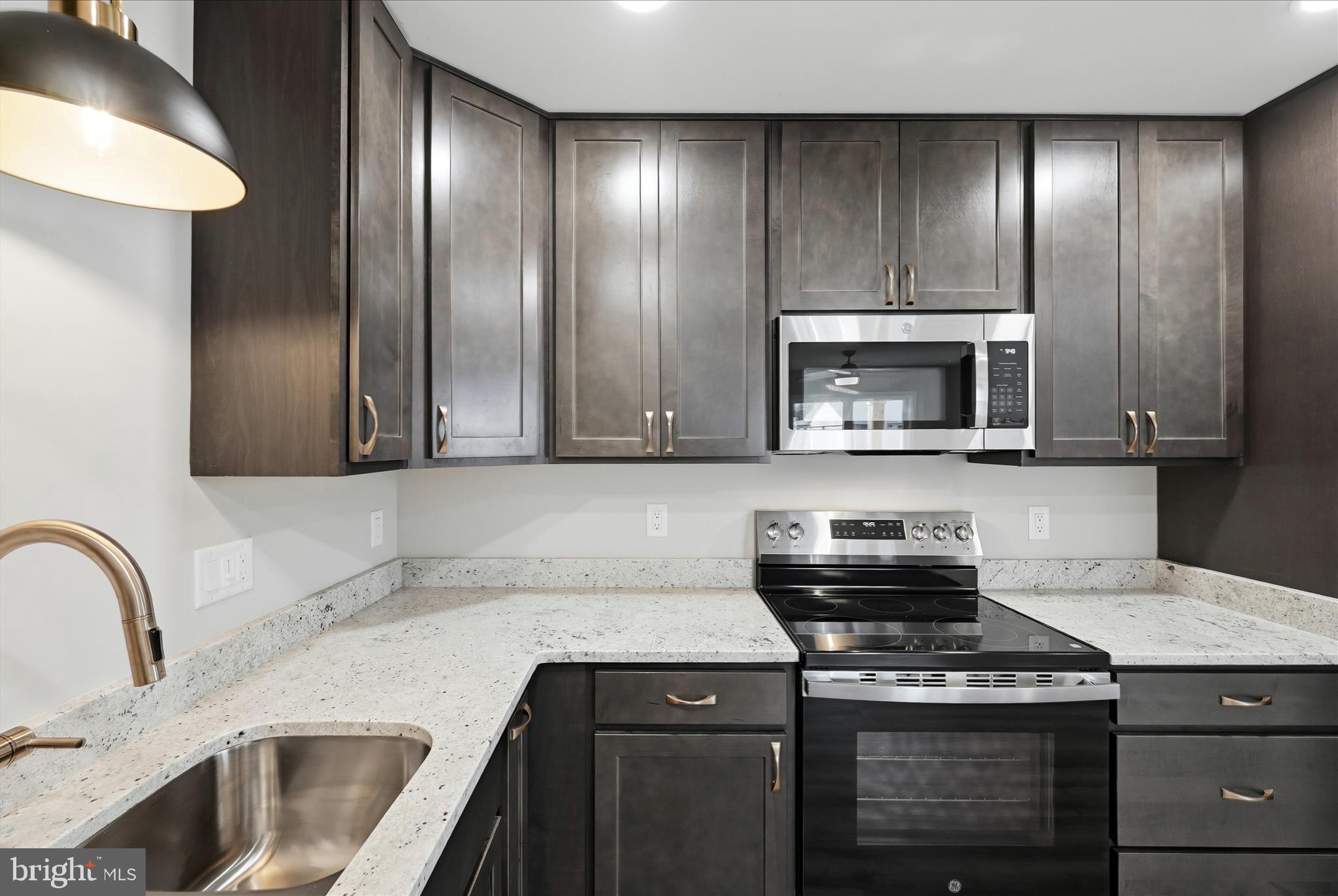 217 Myrtle Avenue Winchester, VA 22601 - Photo 22 of 52 a kitchen with granite countertop a stove a sink and a microwave