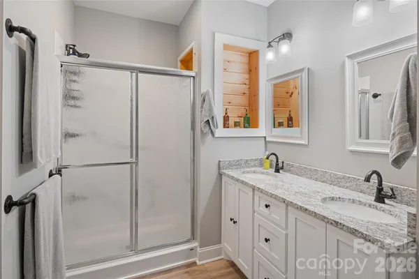 a bathroom with a granite countertop bathtub a sink and a shower