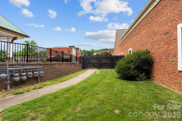 a view of a backyard with potted plants and large tree
