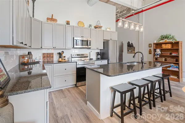 a kitchen with stainless steel appliances granite countertop a sink a stove and cabinets