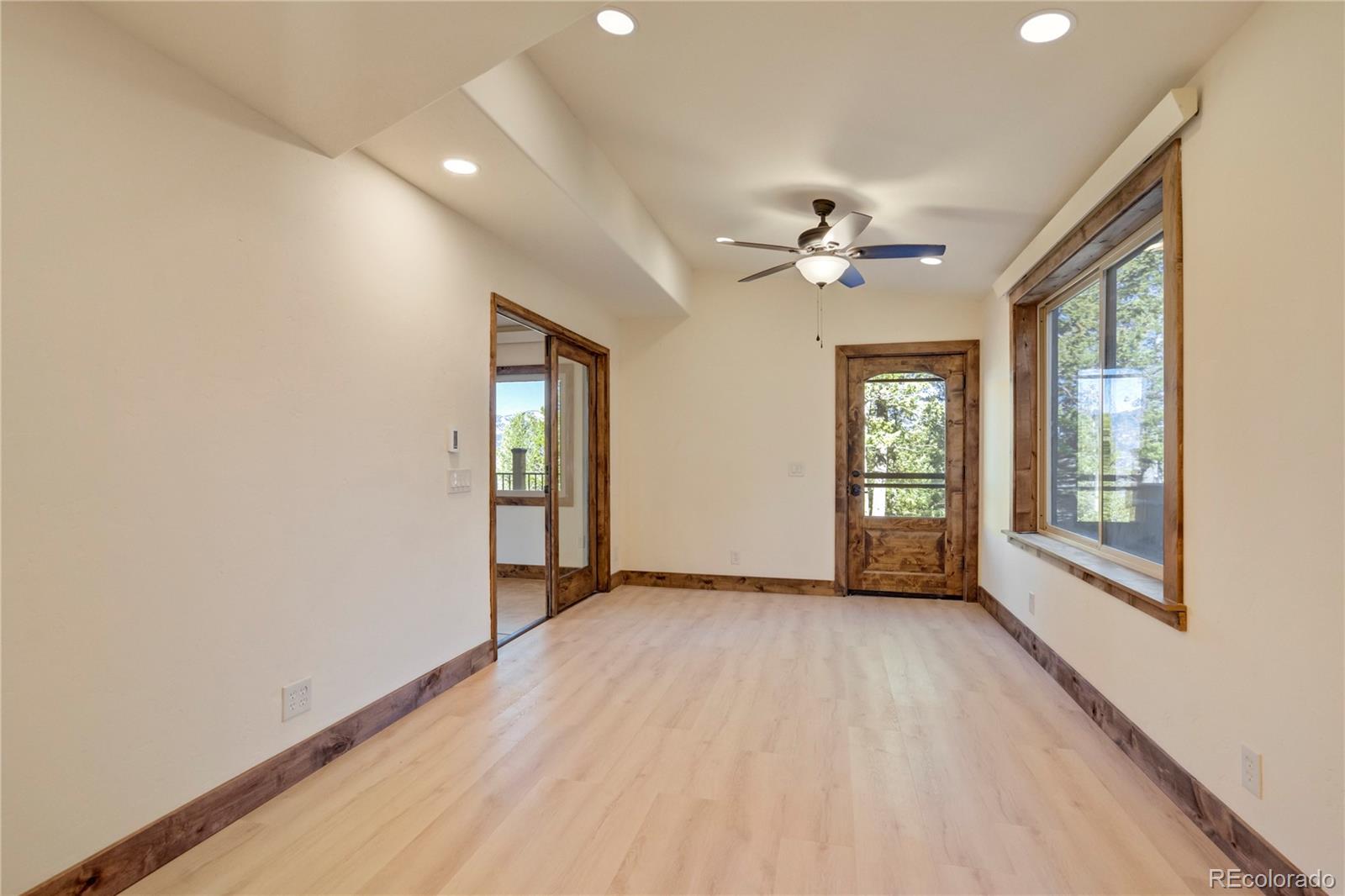 85 Santa Fe Mountain Road Evergreen, CO 80439 - Photo 17 of 47 an empty room with chandelier fan and windows