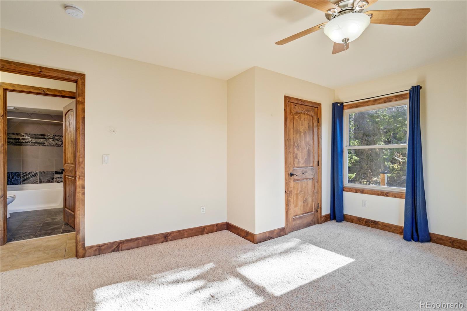 85 Santa Fe Mountain Road Evergreen, CO 80439 - Photo 22 of 47 a view of a livingroom with a chandelier fan and windows