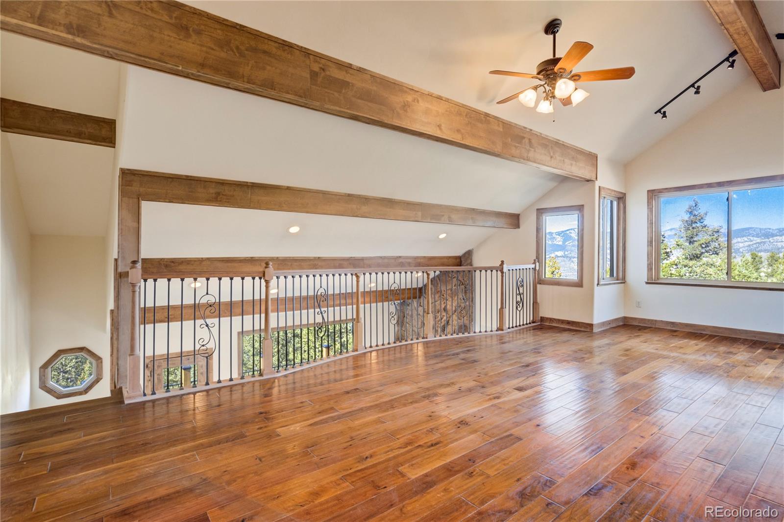 85 Santa Fe Mountain Road Evergreen, CO 80439 - Photo 3 of 47 a view of an empty room with a window and wooden floor