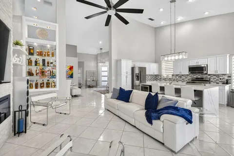 a living room with furniture kitchen view and a chandelier