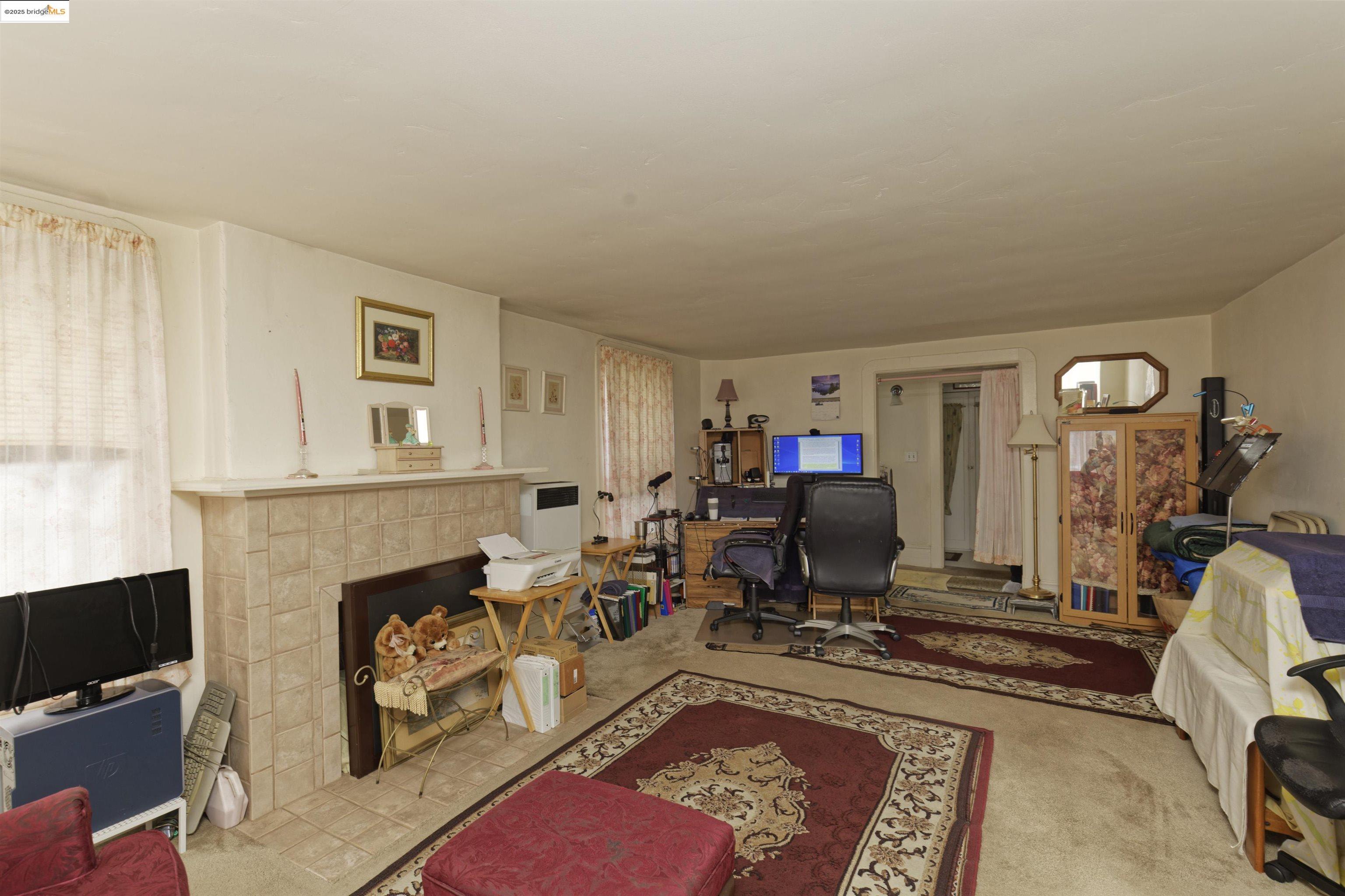 1033 Magnolia Street Oakland, CA 94607 - Photo 18 of 23 a living room with furniture a fireplace and a flat screen tv