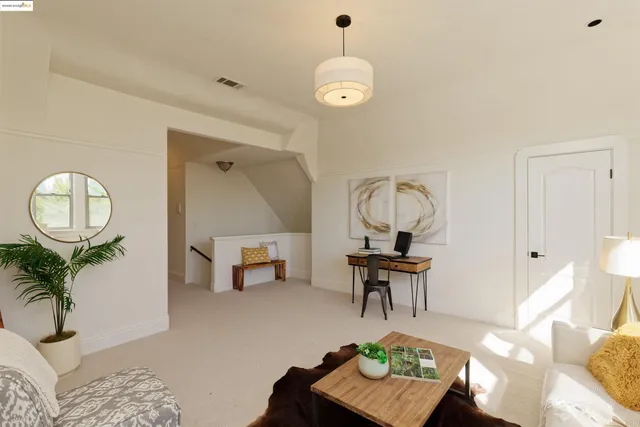 a living room with furniture a mirror and a table