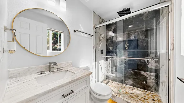 a bathroom with a sink a toilet and shower