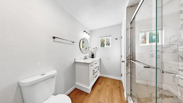 a bathroom with a sink a toilet and shower