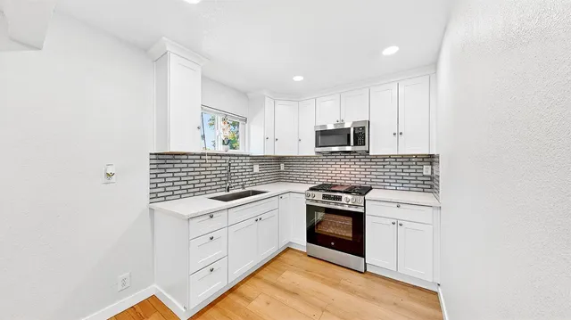a kitchen with a sink stove and cabinets