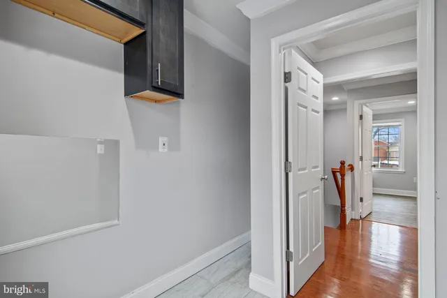 a view of a hallway with wooden floor and a living room