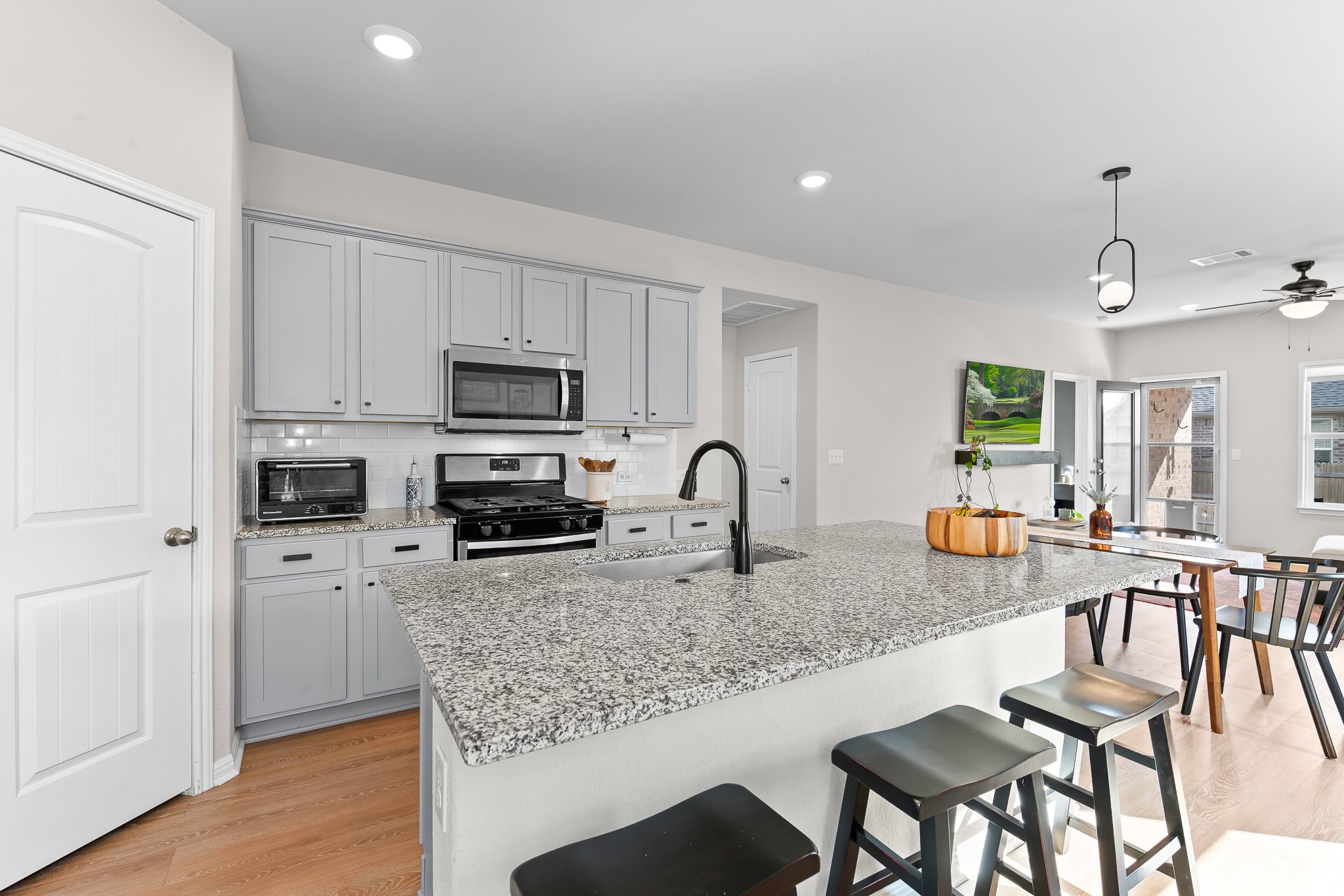 213 Mais Drive Georgetown, TX 78626 - Photo 8 of 39 a kitchen with stainless steel appliances granite countertop a stove top oven a sink a refrigerator with white cabinets and wooden floor