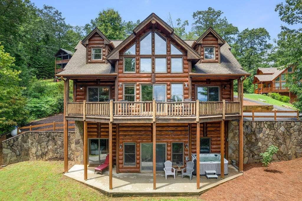 203 Deerfield Lane Blue Ridge, GA 30513 - Photo 1 of 1 a view of a white house with large windows and a small yard