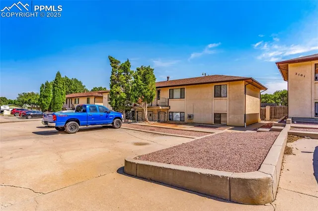 a view of a house with car parked on the road