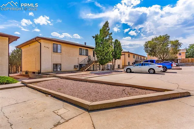 a front view of a house with cars parked