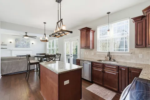 a dining room with wooden floor and a chandelier