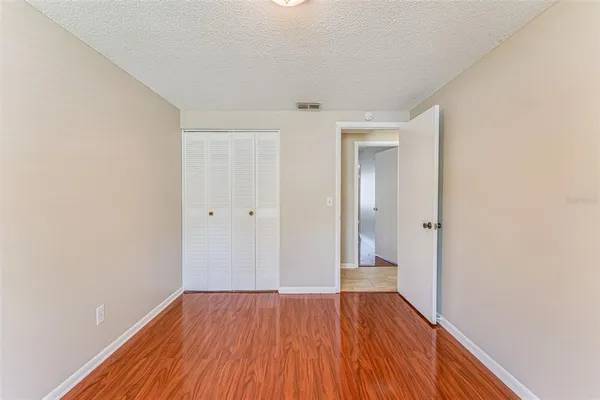 a view of an empty room with wooden floor